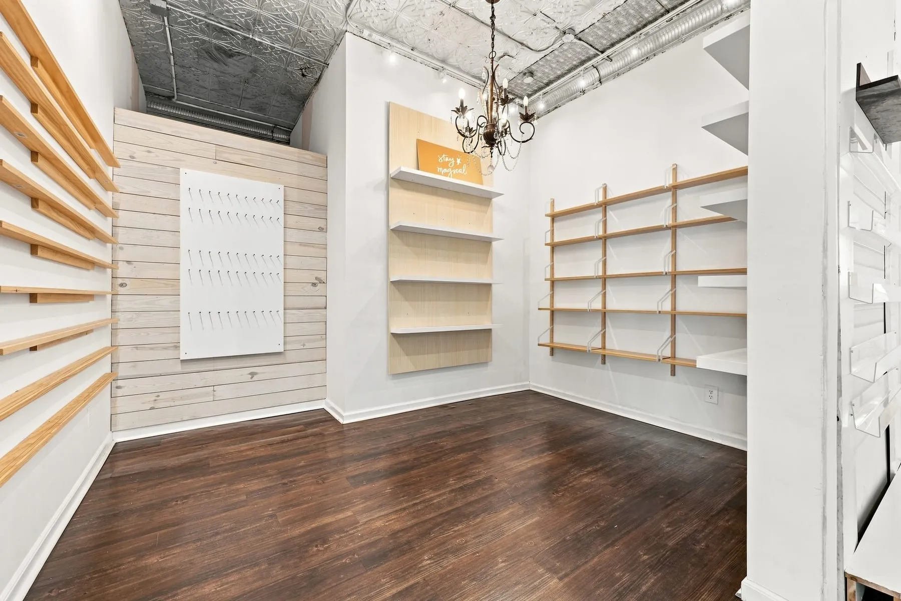 Secondary display room with hardwood floor, built-in shelving and chandelier
