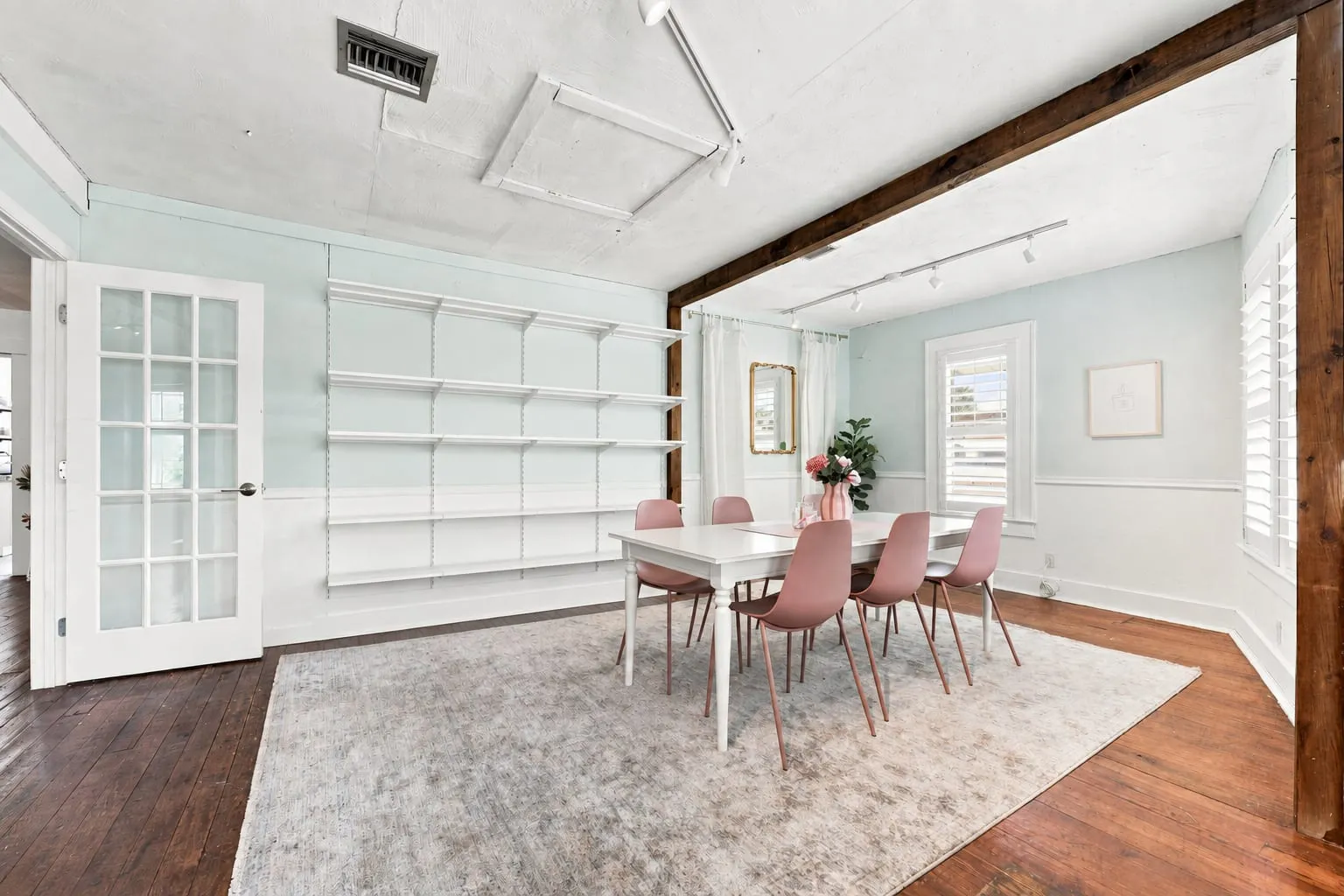 Second floor room with built-in shelving, french doors and hardwood floor